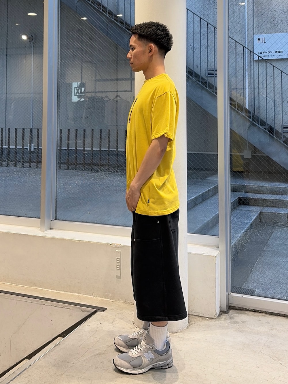 イエロー系のTシャツ/カットソー、グレー系のスウェットパンツを着用したメンズの夏コーディネートの2枚目の写真