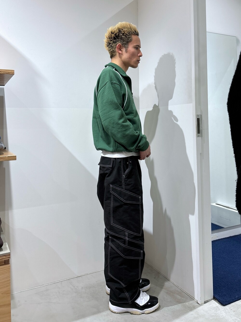 グリーン系のスウェット、ブラック系のカーゴパンツを着用したメンズの冬コーディネートの3枚目の写真