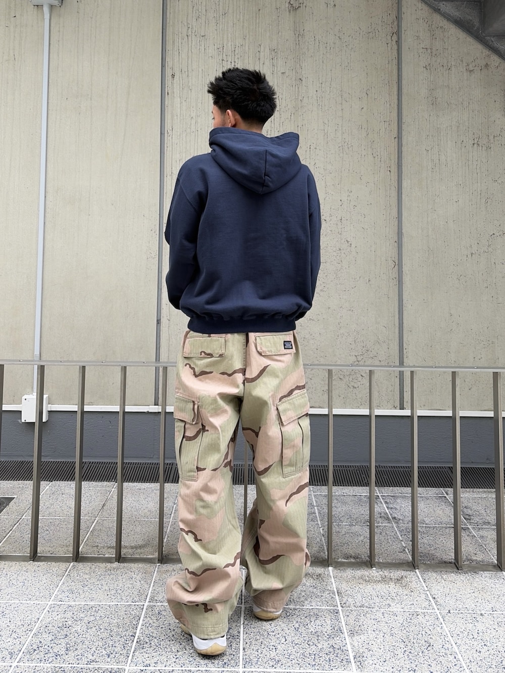 ピンク系のパーカー、グリーン系のカーゴパンツを着用したメンズの春コーディネートの4枚目の写真