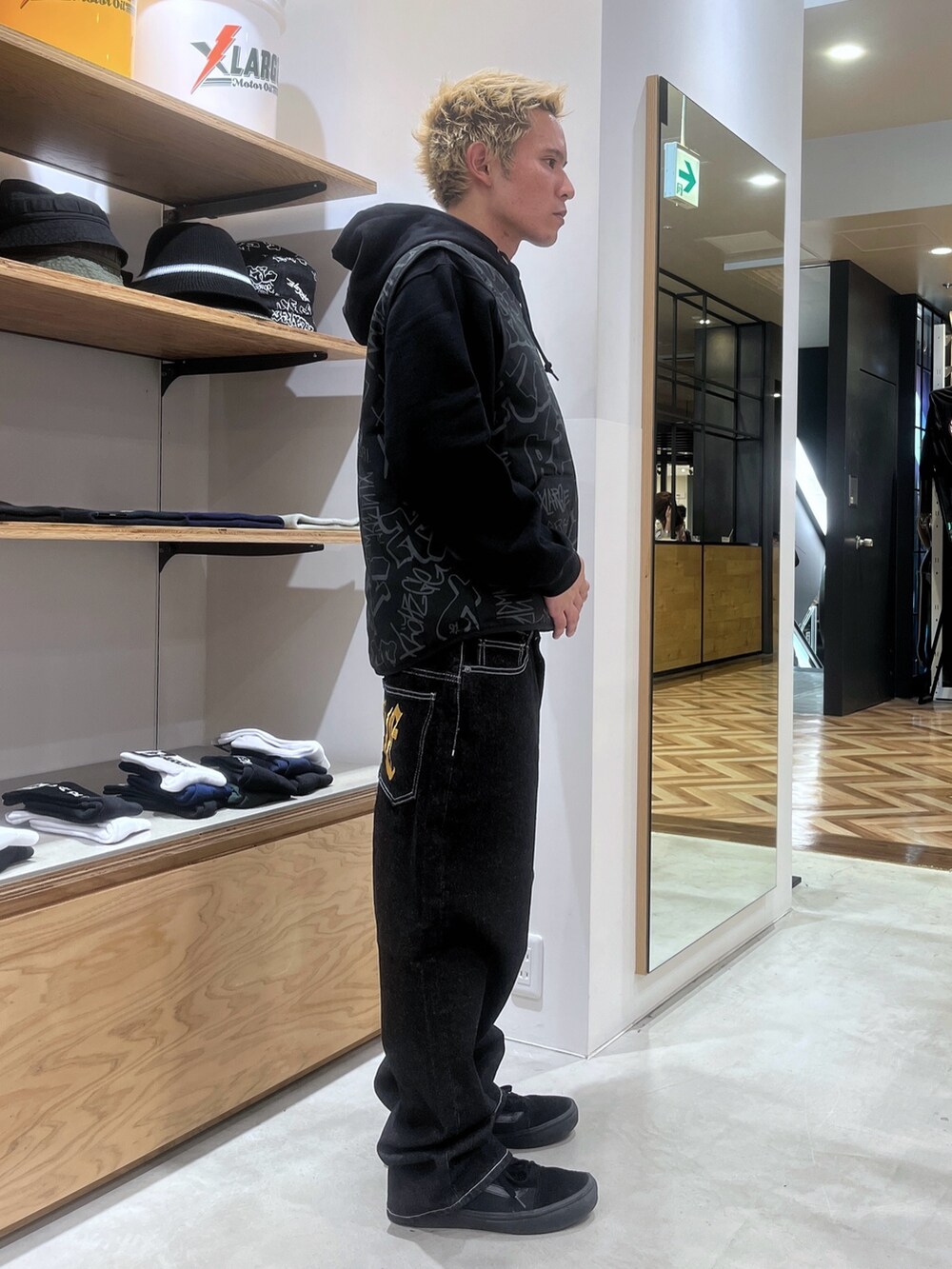 ブラック系のベスト、ブラック系のパーカー、ブラック系のデニムパンツを着用したメンズの秋コーディネートの3枚目の写真