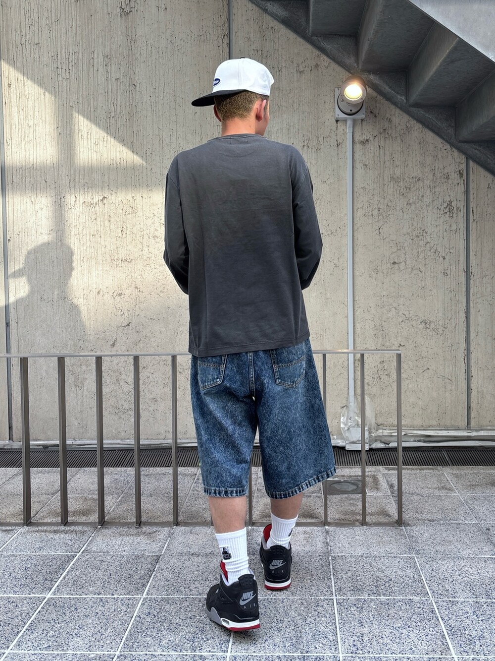 ブラック系のTシャツ/カットソー、ブルー系のその他パンツ、ホワイト系のキャップを着用したメンズの春コーディネートの4枚目の写真