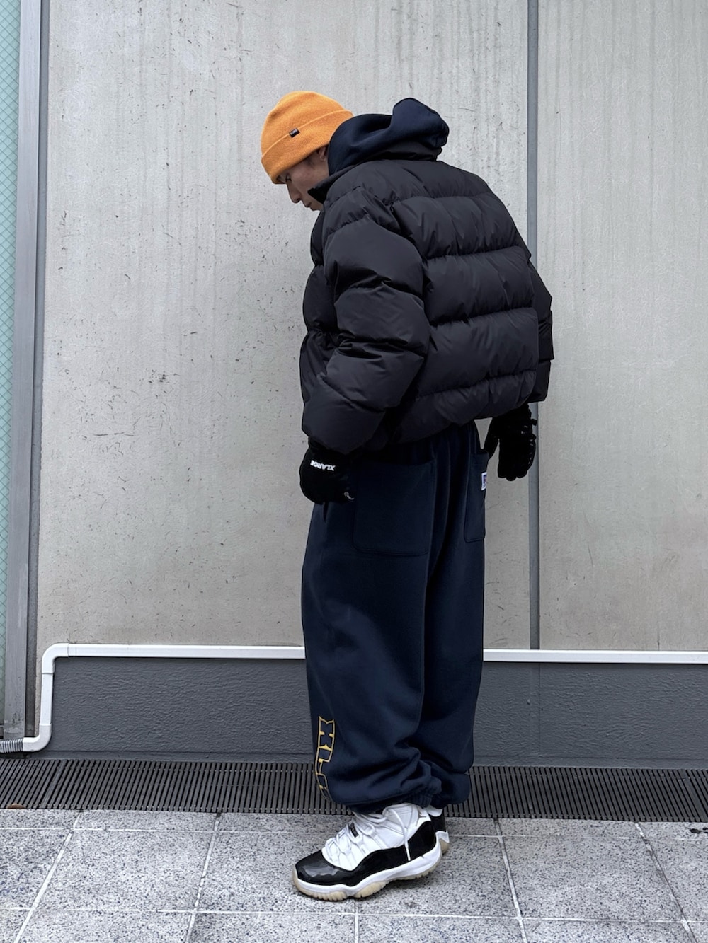 ブラック系のダウンジャケット/コート、ブルー系のパーカー、ブルー系のスウェットパンツを着用したメンズの秋コーディネートの3枚目の写真