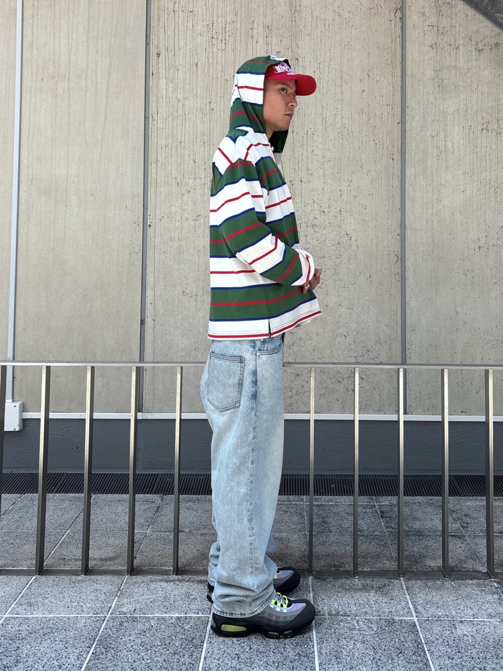 ホワイト系のTシャツ/カットソー、ブラック系のデニムパンツ、レッド系のキャップを着用したメンズの秋コーディネートの3枚目の写真