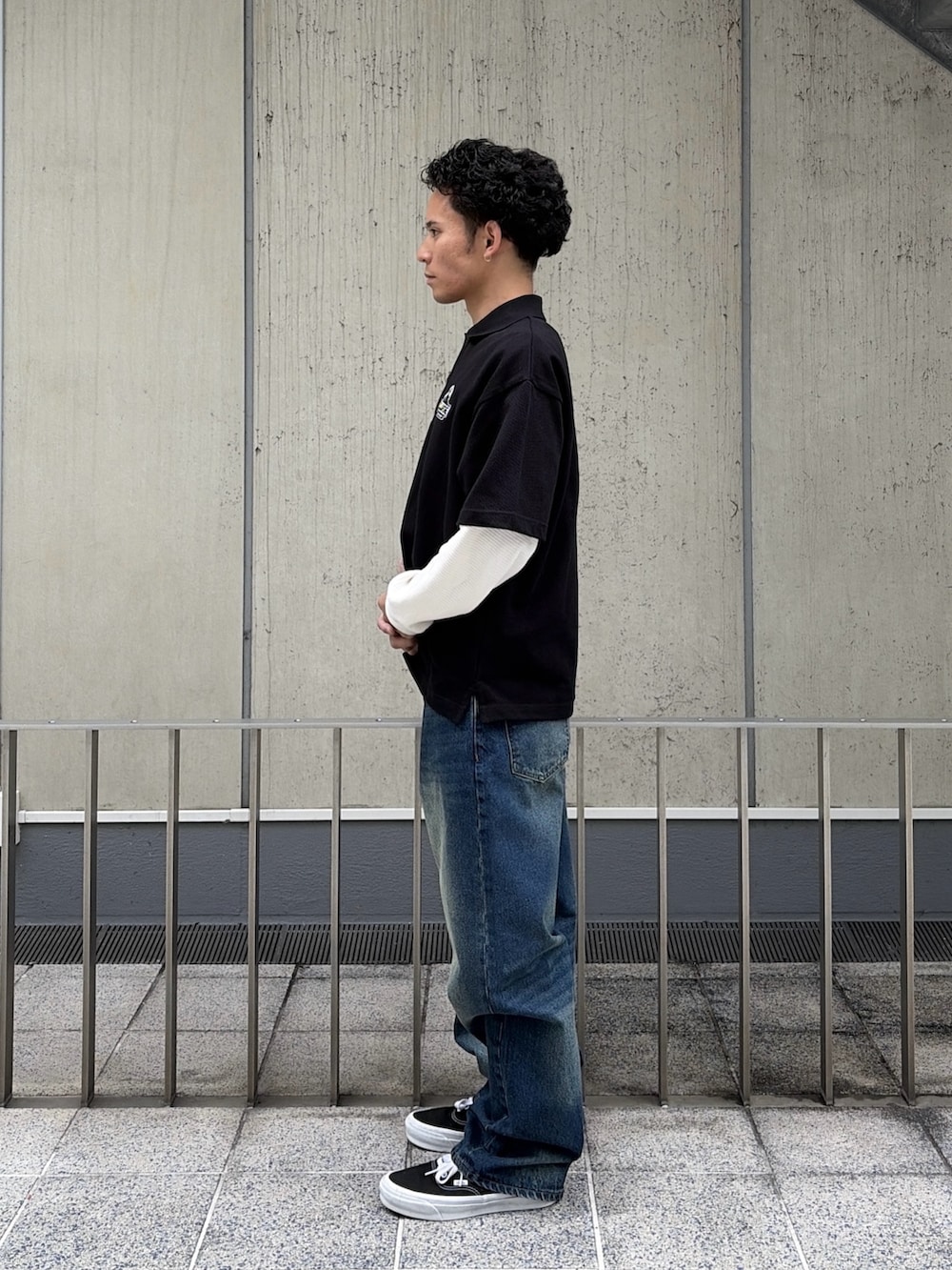 ホワイト系のTシャツ/カットソー、ブラック系のポロシャツ、ブルー系のデニムパンツを着用したメンズの春コーディネートの2枚目の写真