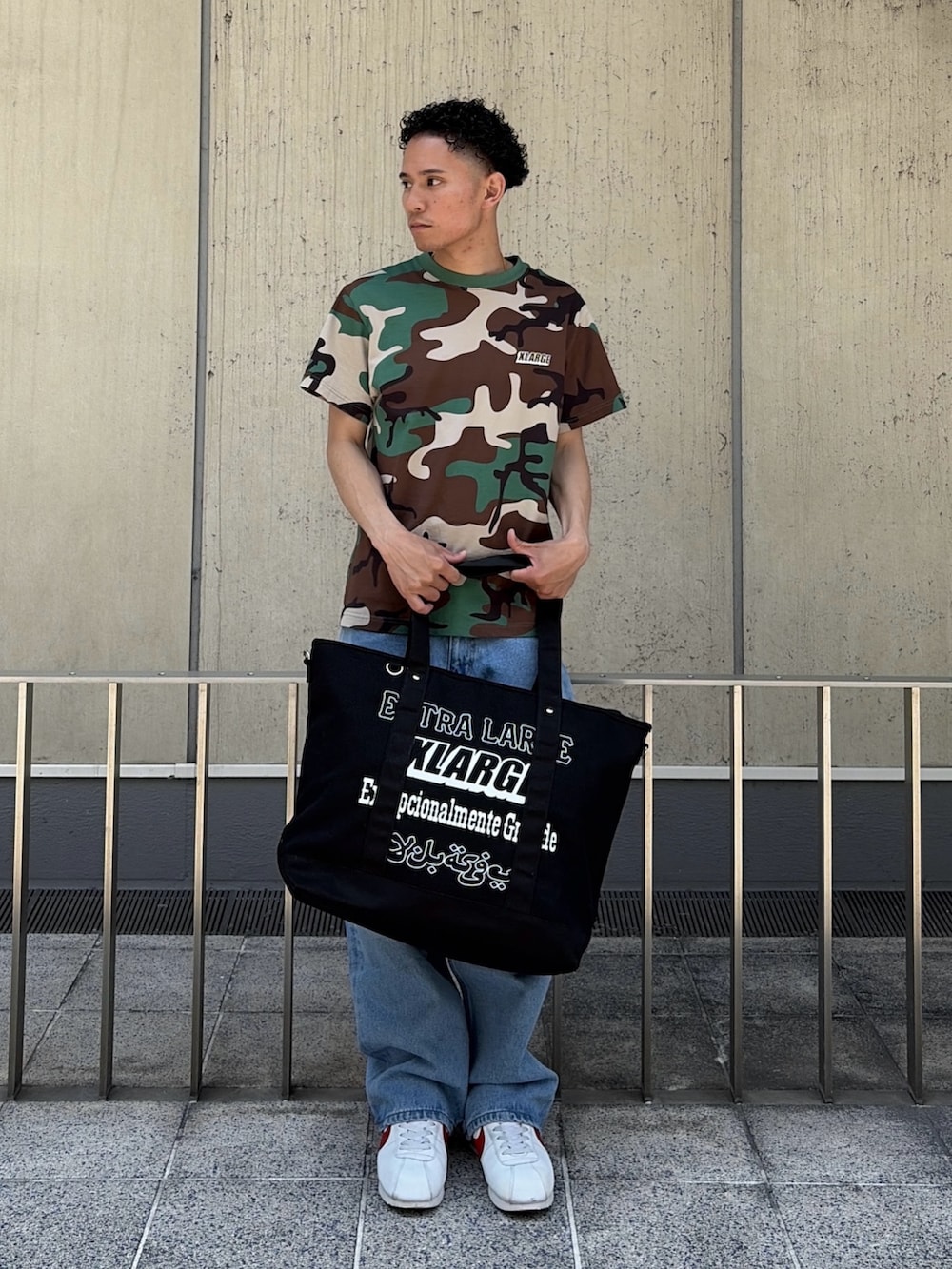 その他のTシャツ/カットソー、ブルー系のデニムパンツ、ブラック系のトートバッグを着用したメンズの夏コーディネートの5枚目の写真