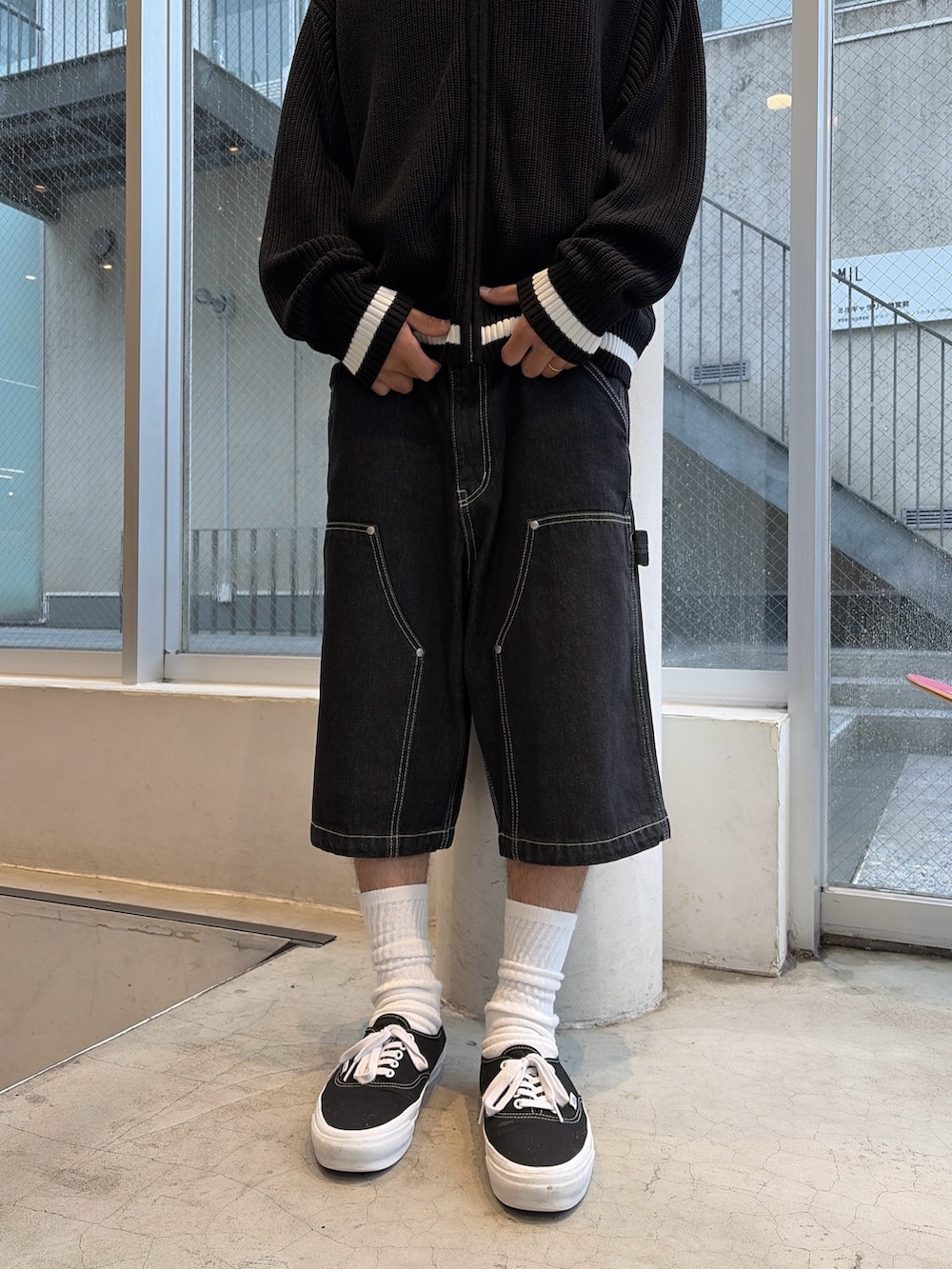 ブラック系のニット/セーター、ブラック系のデニムパンツを着用したメンズの秋コーディネートの9枚目の写真