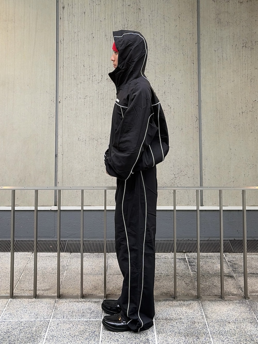 ブラック系のブルゾン、ブラック系のその他パンツ、レッド系のニットキャップ/ビーニーを着用したメンズの秋コーディネートの2枚目の写真