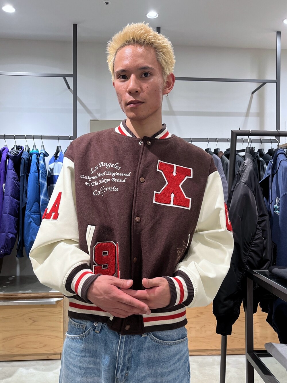 ブラウン系のスタジャン、ブルー系のデニムパンツを着用したメンズの秋コーディネートの5枚目の写真