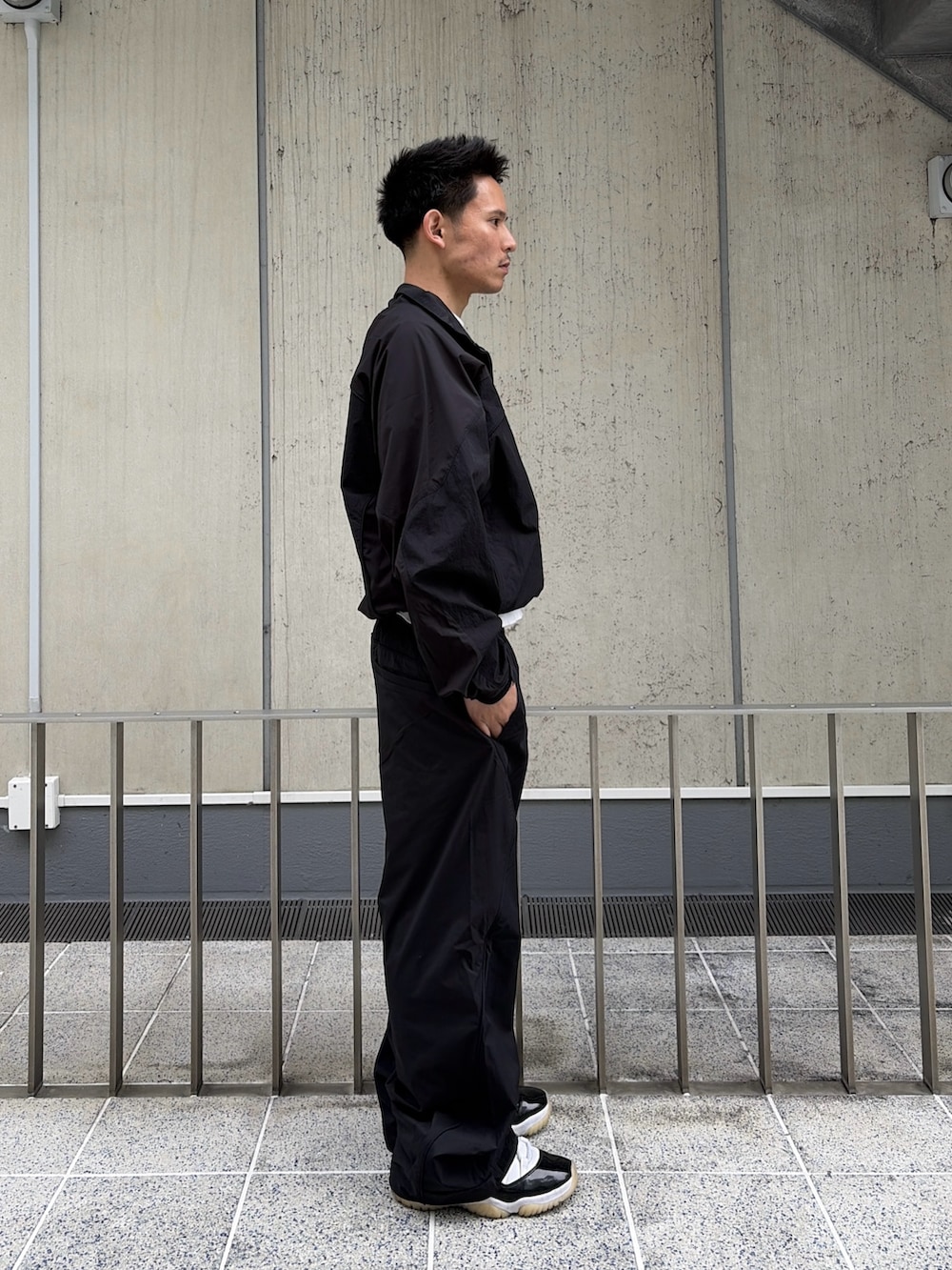 ブラック系のナイロンジャケット、ブラック系のその他パンツを着用したメンズの春コーディネートの3枚目の写真