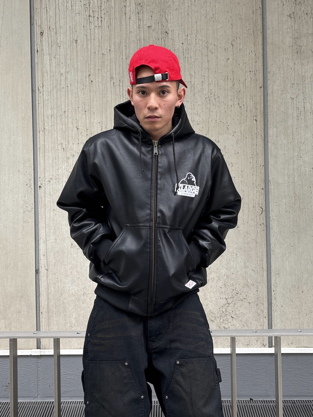 ブラック系のその他アウター、ブラウン系のその他パンツ、レッド系のキャップを着用したメンズの冬コーディネートの6枚目の写真