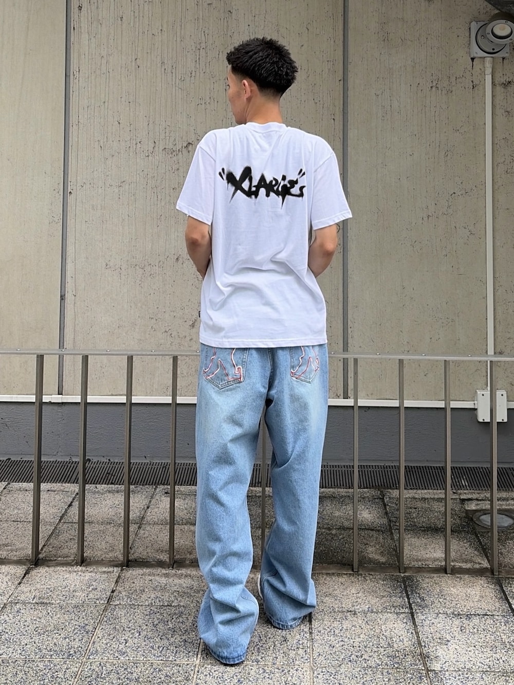 ホワイト系のTシャツ/カットソー、ブルー系のデニムパンツを着用したメンズの夏コーディネートの4枚目の写真
