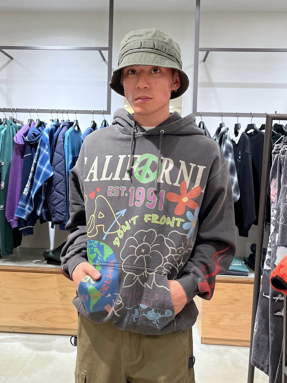 グリーン系のブルゾン、ブラック系のパーカー、グリーン系のその他パンツを着用したメンズの秋コーディネートの5枚目の写真