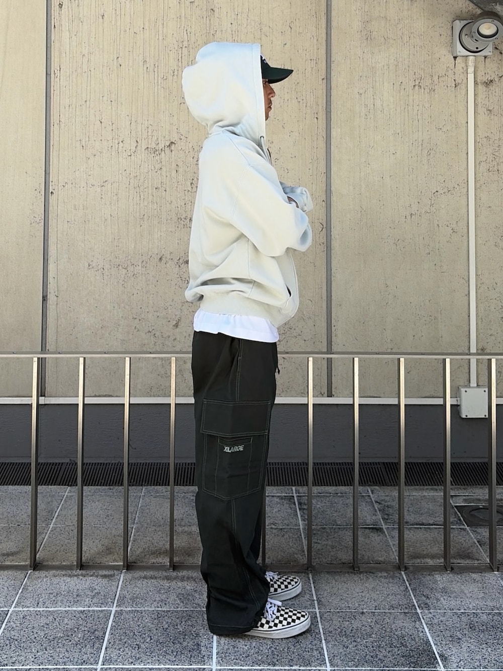 ブラック系のパーカー、グリーン系のカーゴパンツ、グリーン系のキャップを着用したメンズの夏コーディネートの4枚目の写真
