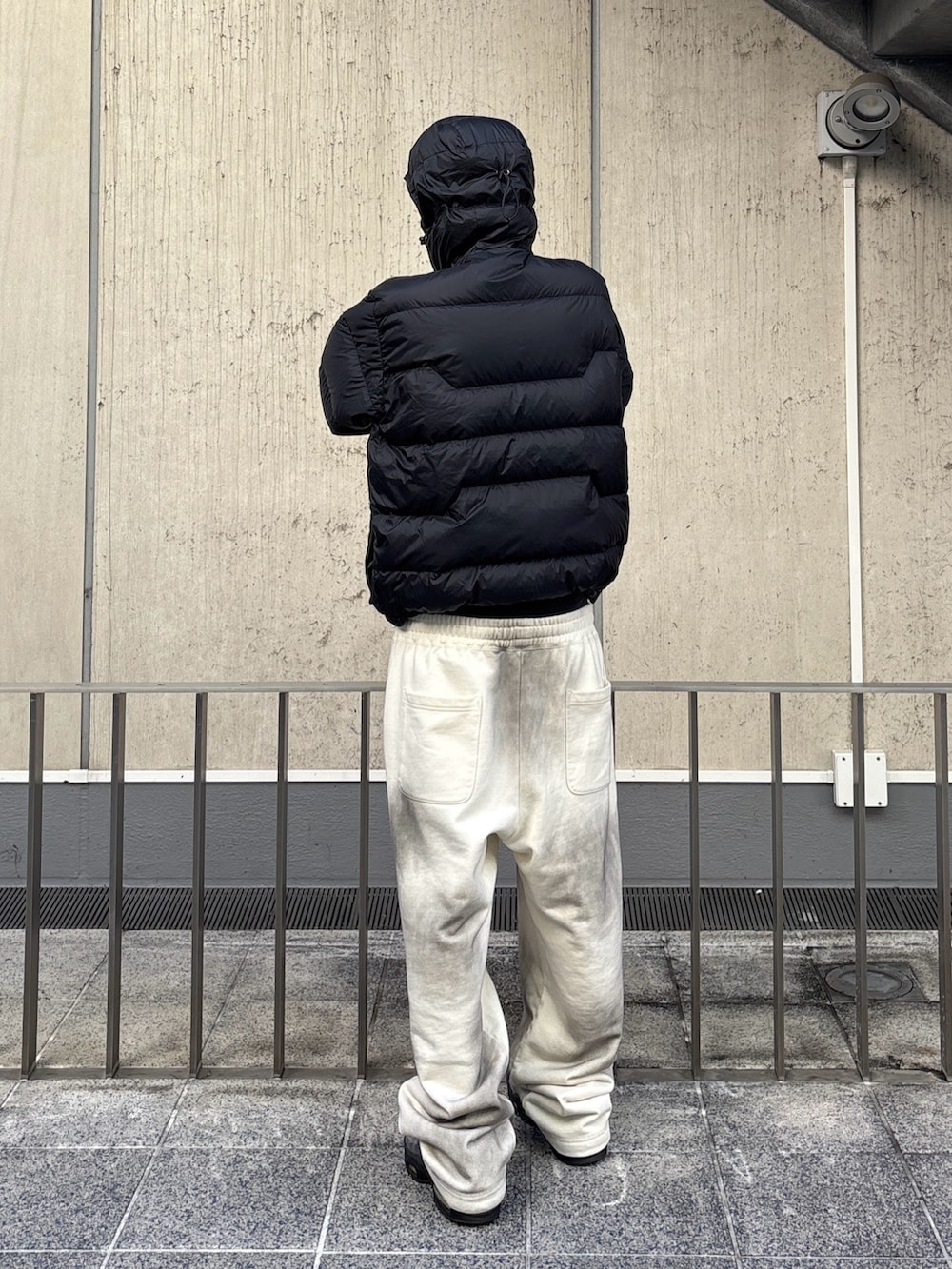 ブラウン系のダウンジャケット/コート、ホワイト系のスウェットパンツを着用したメンズの秋コーディネートの4枚目の写真