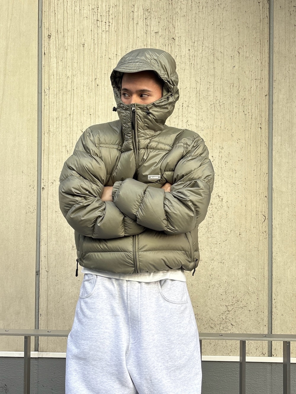 グリーン系のダウンジャケット/コート、グレー系のスウェットパンツを着用したメンズの冬コーディネートの6枚目の写真