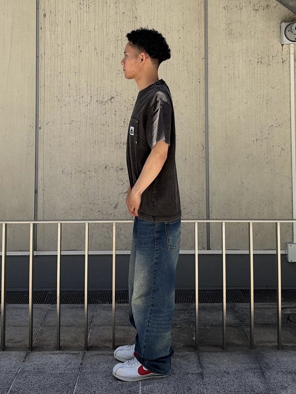 ブラック系のTシャツ/カットソー、ブルー系のデニムパンツを着用したメンズの夏コーディネートの2枚目の写真