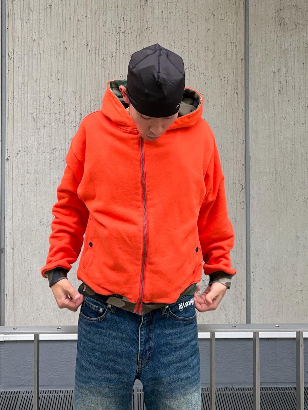 オレンジ系のパーカー、ブルー系のデニムパンツ、その他のニットキャップ/ビーニーを着用したメンズの秋コーディネートの9枚目の写真