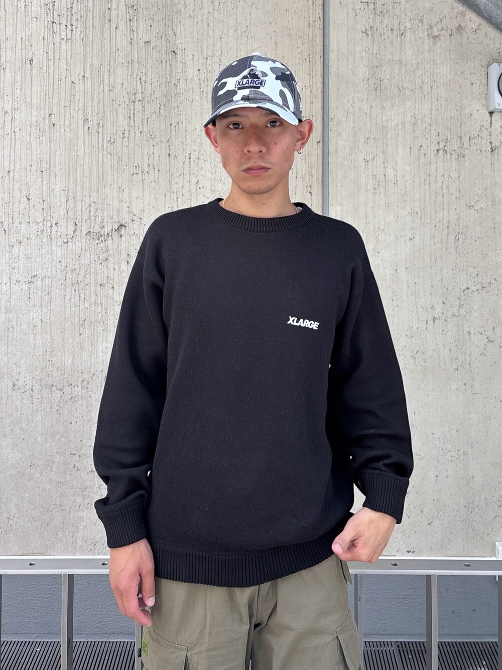 ブラック系のニット/セーター、グリーン系のカーゴパンツ、その他のキャップを着用したメンズの秋コーディネートの7枚目の写真