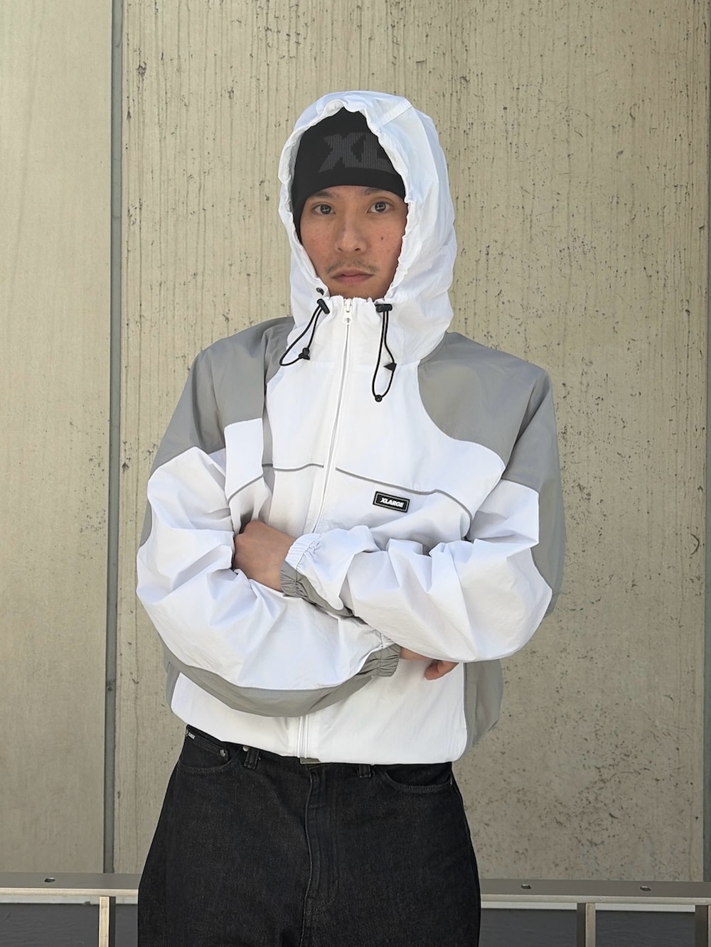 ブルー系のナイロンジャケット、ブラック系のデニムパンツ、ピンク系のニットキャップ/ビーニーを着用したメンズの春コーディネートの6枚目の写真