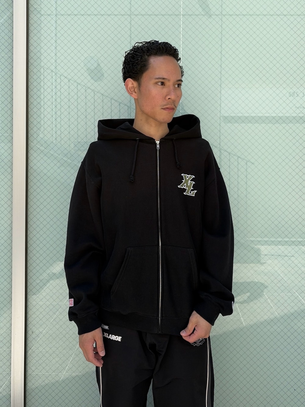 ブラウン系のパーカー、ブラック系のその他パンツを着用したメンズの春コーディネートの5枚目の写真