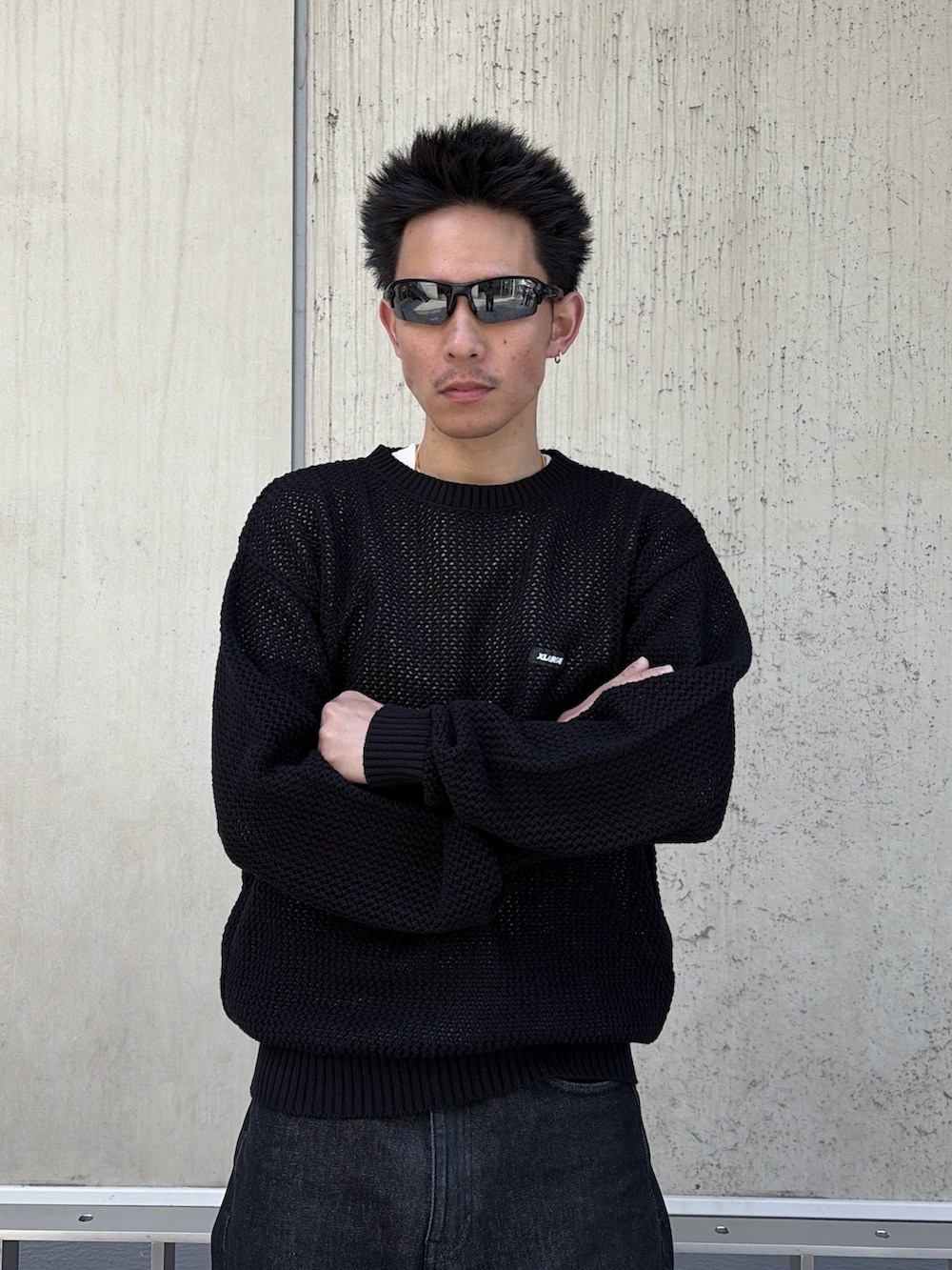 ブラック系のニット/セーター、ブラック系のデニムパンツを着用したメンズの春コーディネートの5枚目の写真