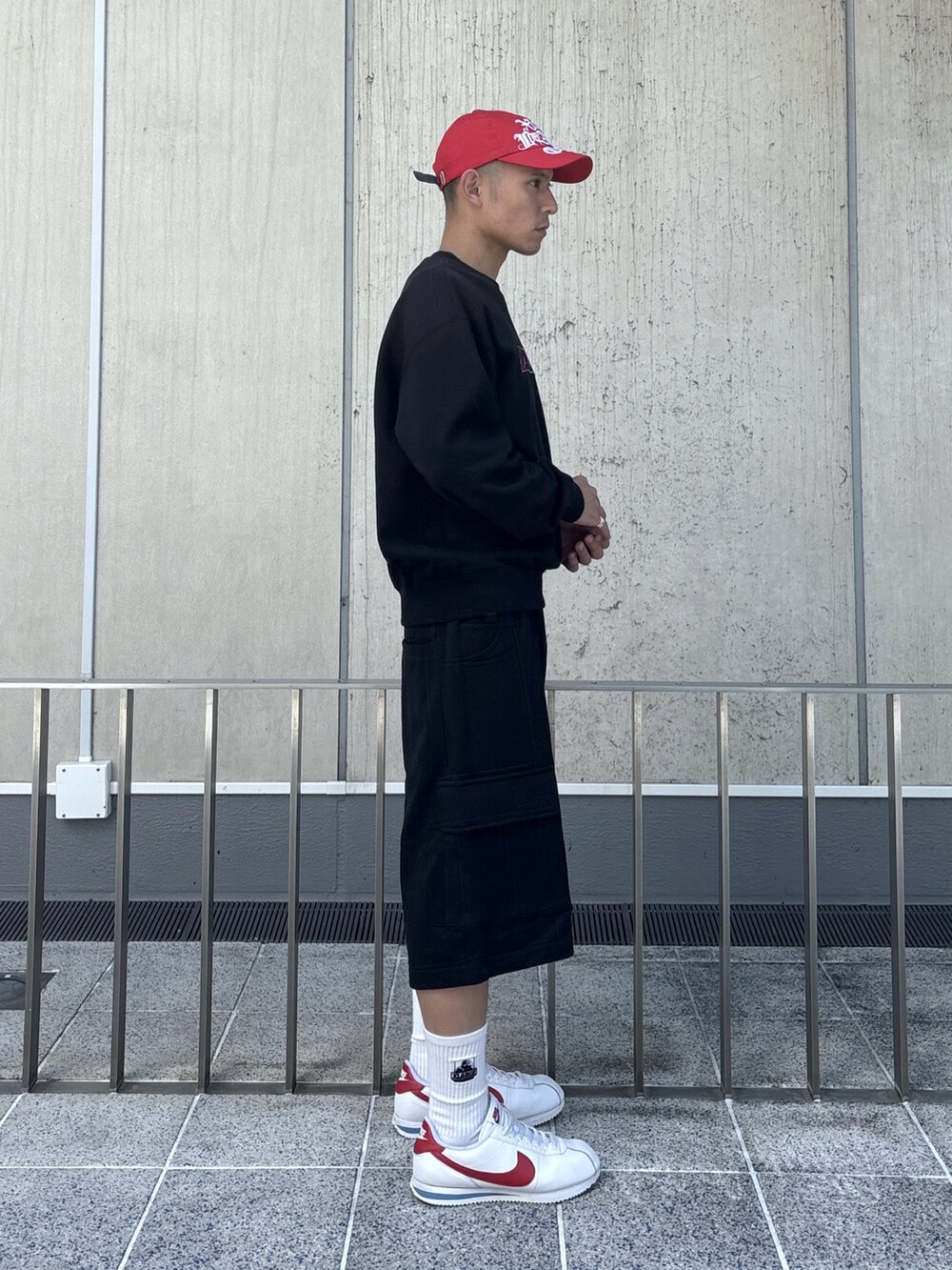 ブラック系のスウェット、ブラック系のスウェットパンツ、レッド系のキャップを着用したメンズの秋コーディネートの4枚目の写真