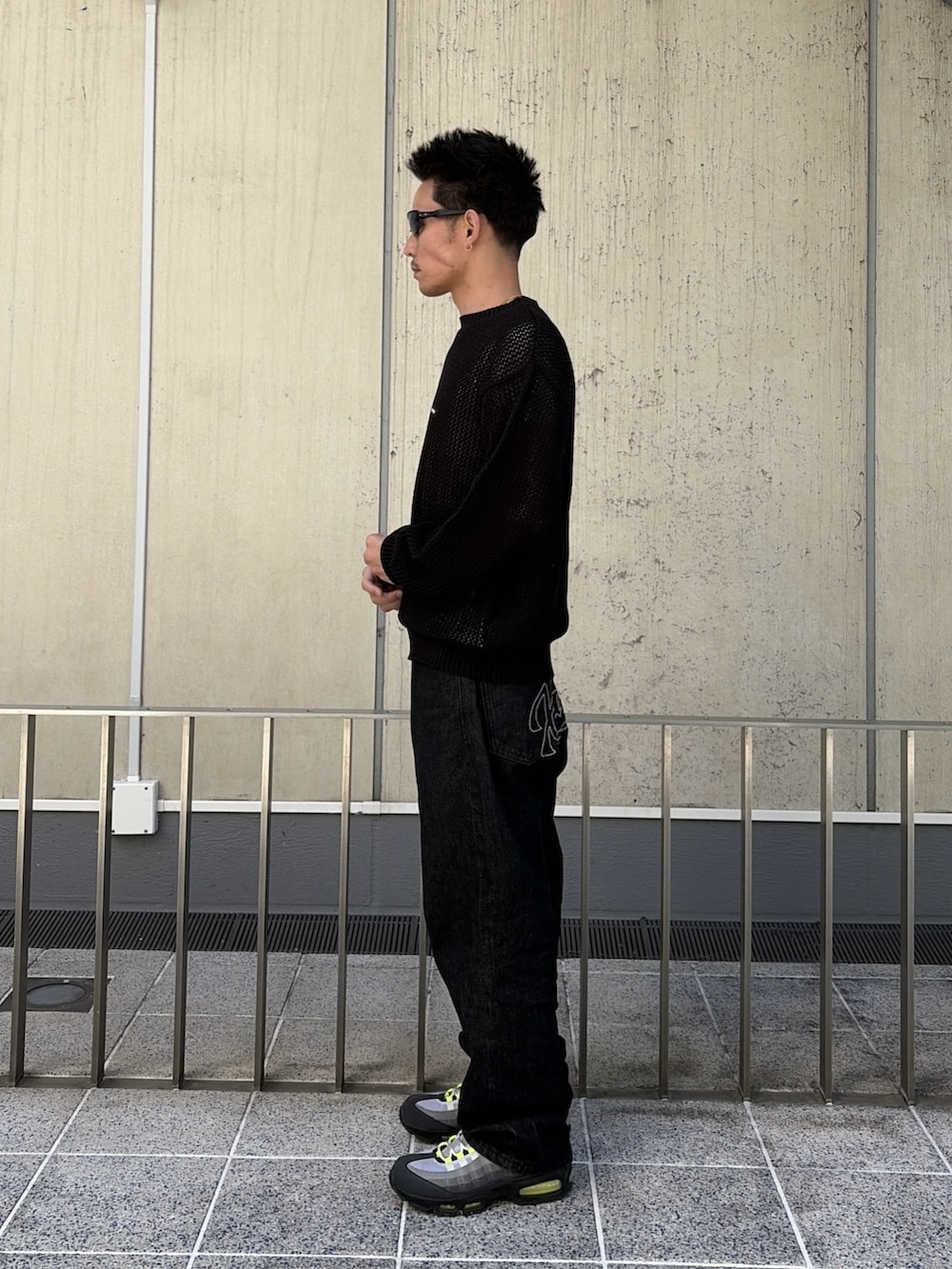 ブラック系のニット/セーター、ブラック系のデニムパンツを着用したメンズの春コーディネートの2枚目の写真