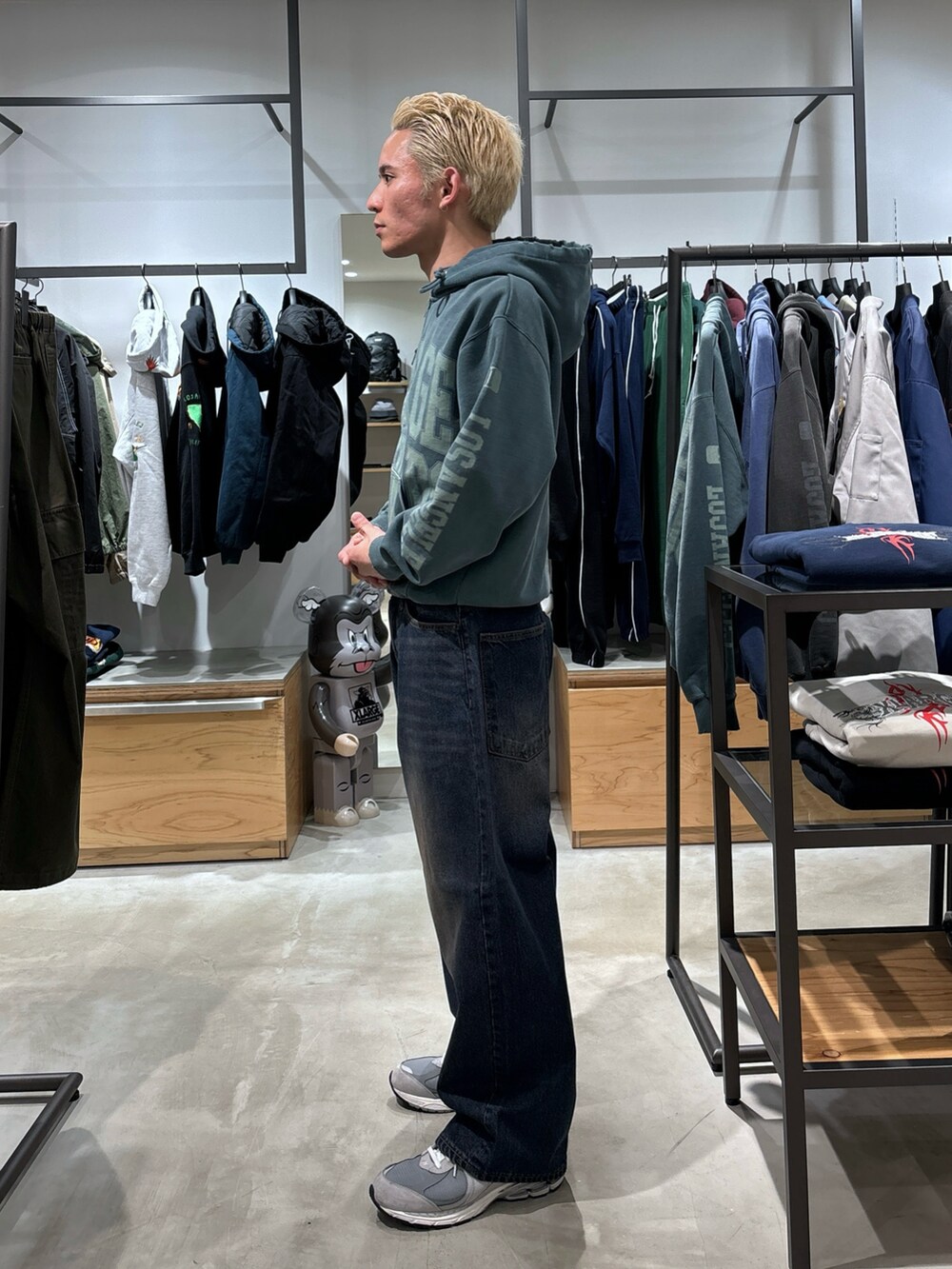 グリーン系のパーカー、ブルー系のデニムパンツを着用したメンズの冬コーディネートの2枚目の写真