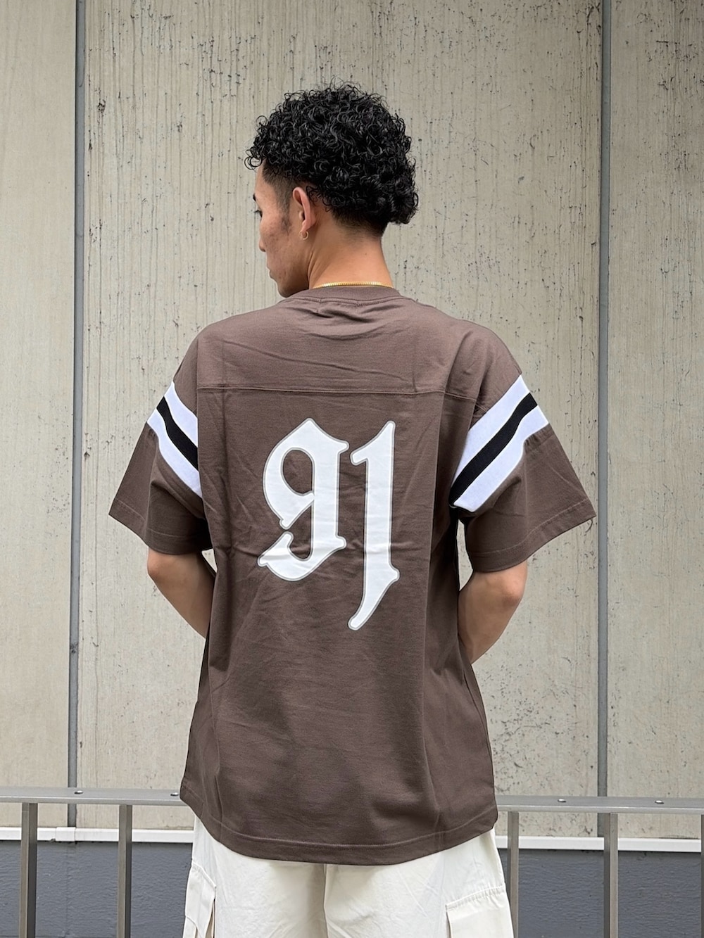 ブラウン系のTシャツ/カットソー、ホワイト系のカーゴパンツを着用したメンズの夏コーディネートの6枚目の写真