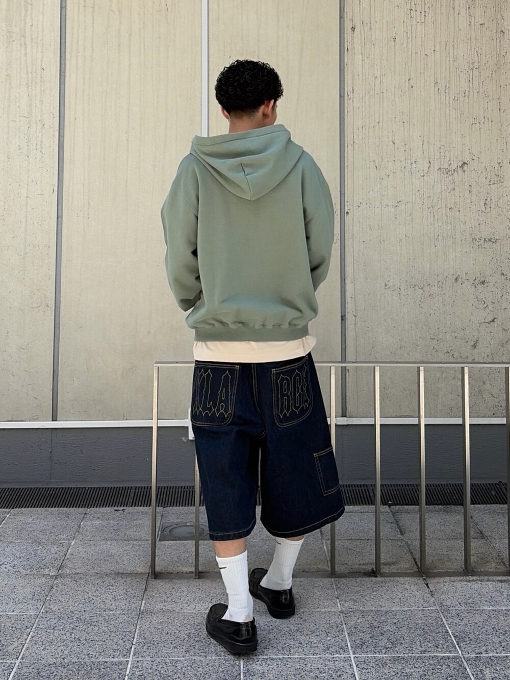 ピンク系のパーカー、ブルー系のデニムパンツを着用したメンズの春コーディネートの5枚目の写真