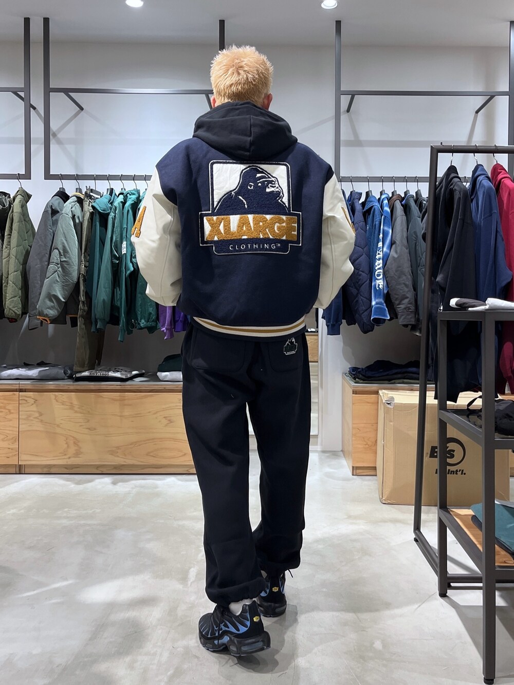ブルー系のスタジャン、ブラック系のスウェットパンツ、ブラック系のパーカーを着用したメンズの秋コーディネートの4枚目の写真