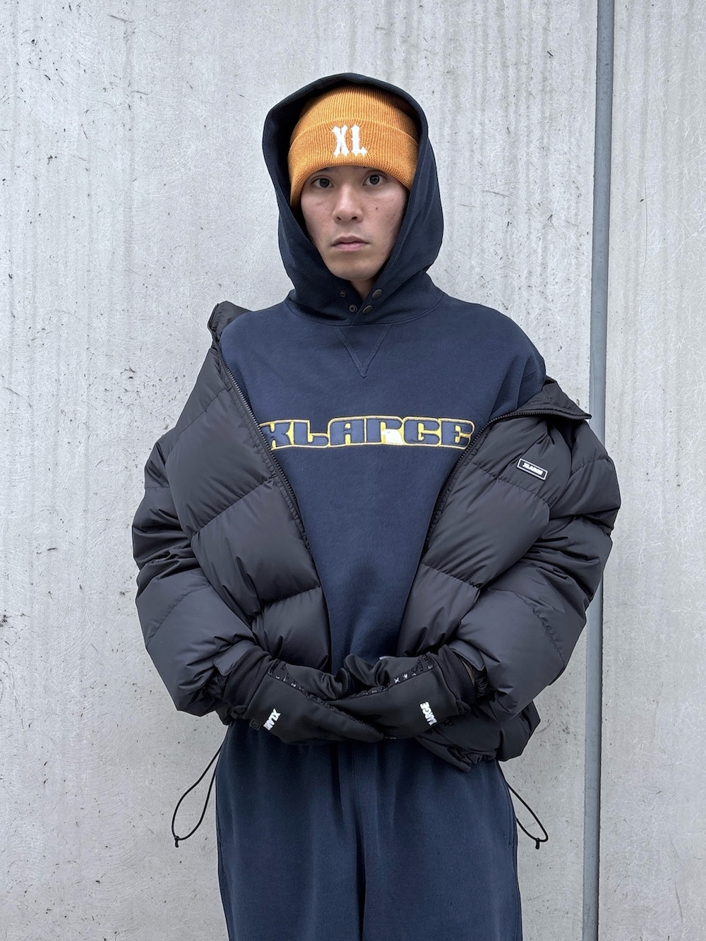 ブラック系のダウンジャケット/コート、ブルー系のパーカー、ブルー系のスウェットパンツを着用したメンズの秋コーディネートの6枚目の写真