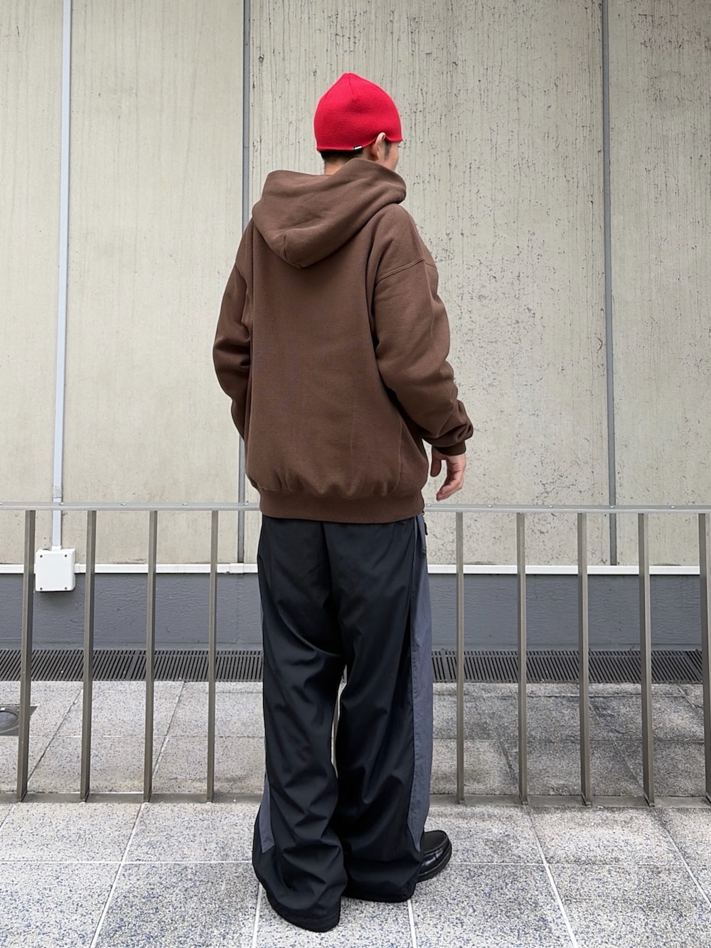 ブラウン系のパーカー、レッド系のその他パンツ、レッド系のニットキャップ/ビーニーを着用したメンズの秋コーディネートの6枚目の写真