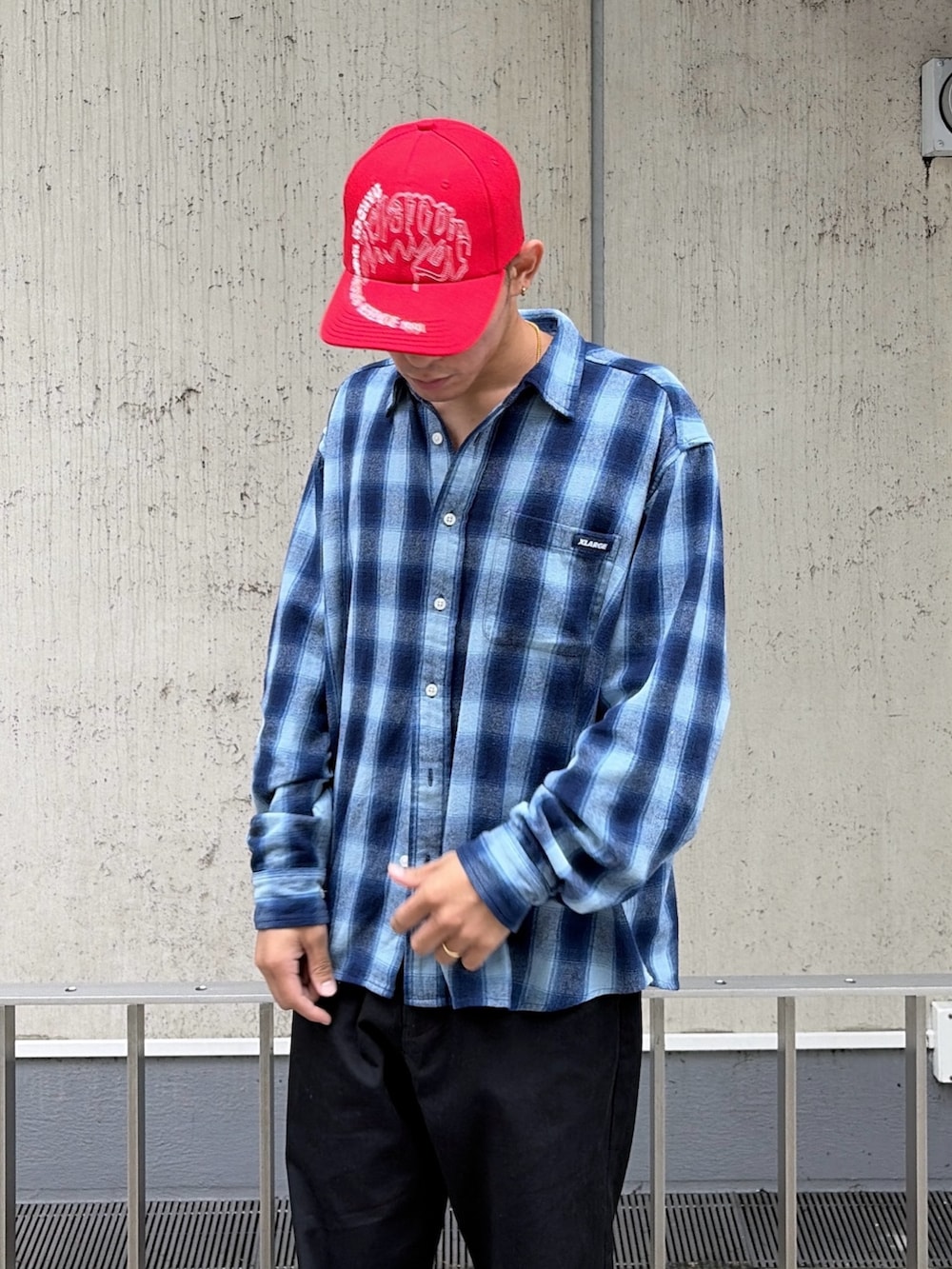 ブルー系のシャツ/ブラウス、ブラック系のその他パンツ、レッド系のキャップを着用したメンズの秋コーディネートの7枚目の写真
