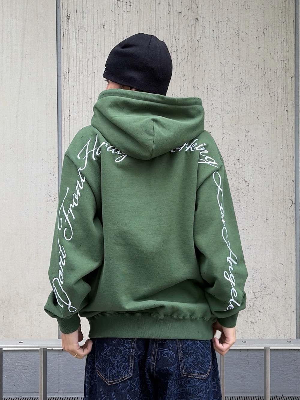 グリーン系のパーカー、ブルー系のデニムパンツ、レッド系のニットキャップ/ビーニーを着用したメンズの秋コーディネートの10枚目の写真