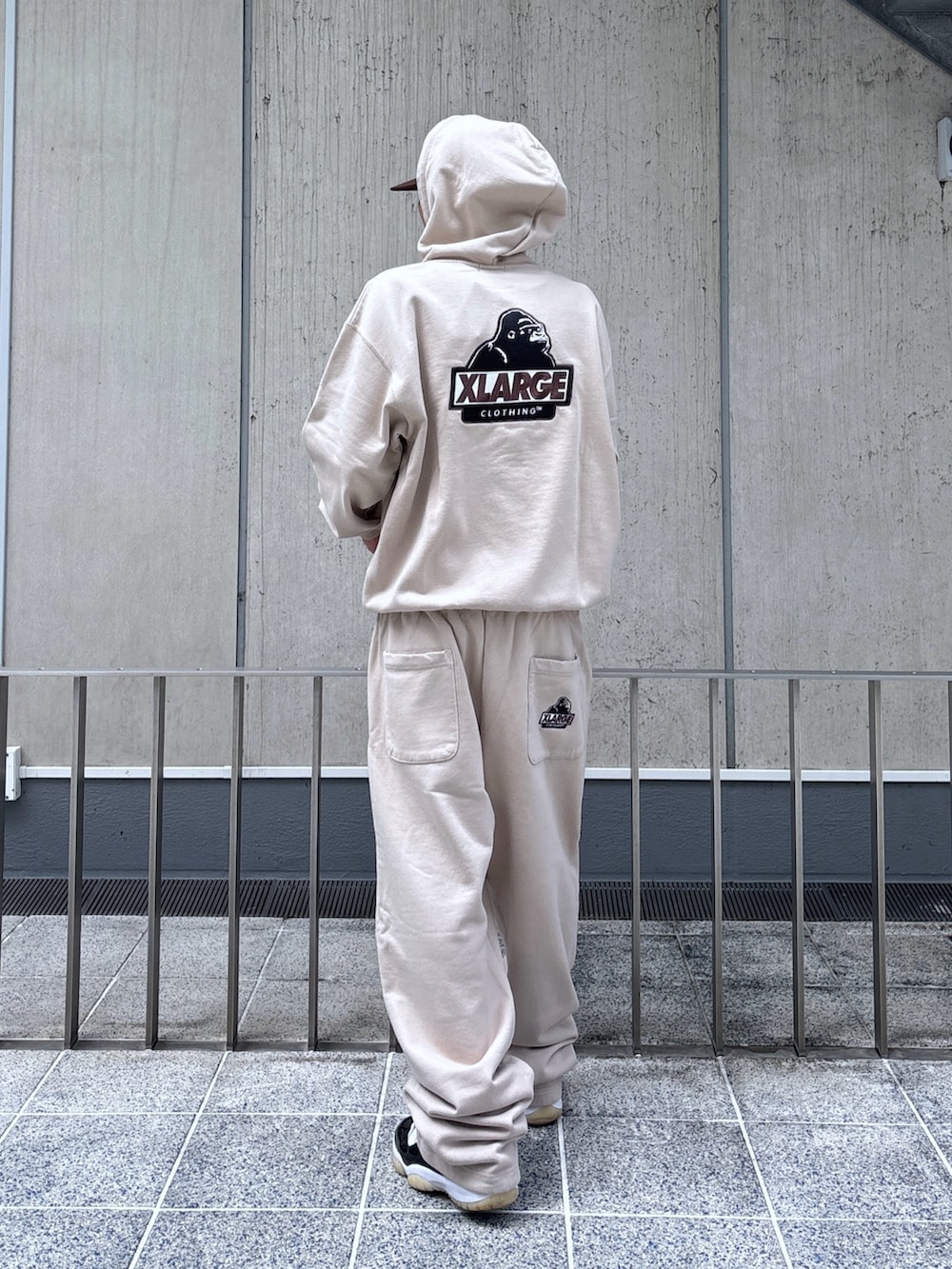 ベージュ系のスウェットパンツ、ベージュ系のパーカー、ブラウン系のキャップを着用したメンズの秋コーディネートの5枚目の写真