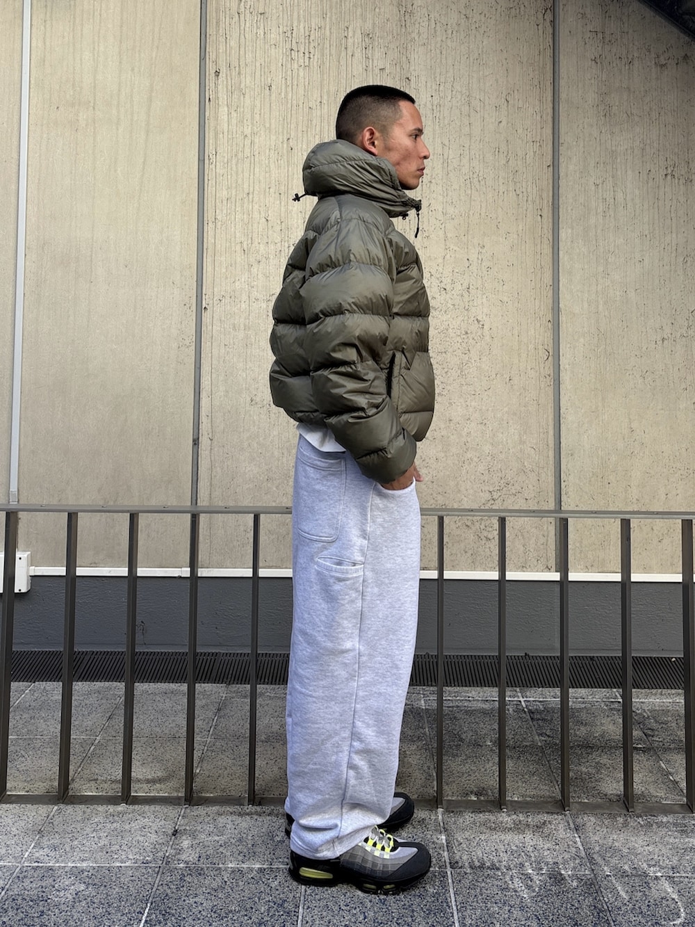 グリーン系のダウンジャケット/コート、グレー系のスウェットパンツを着用したメンズの冬コーディネートの4枚目の写真