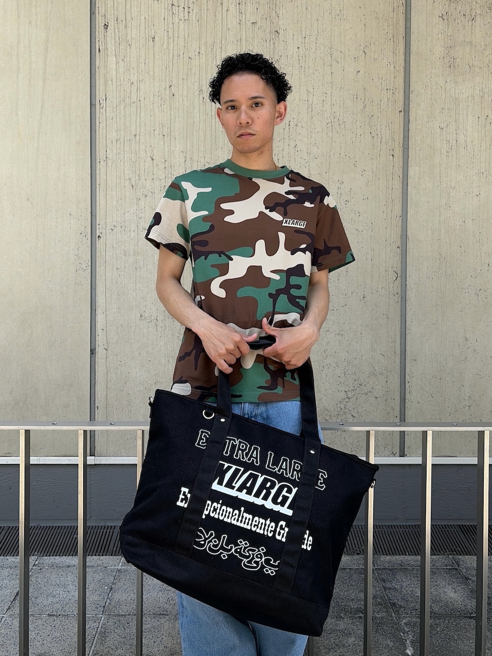 その他のTシャツ/カットソー、ブルー系のデニムパンツ、ブラック系のトートバッグを着用したメンズの夏コーディネートの6枚目の写真