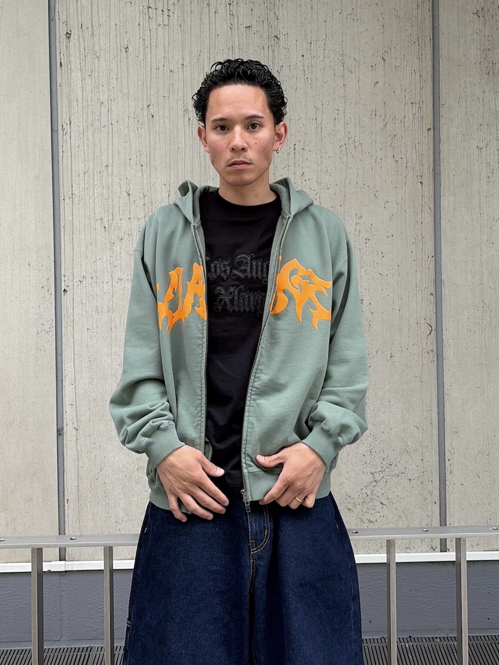 ピンク系のパーカー、ブルー系のデニムパンツを着用したメンズの春コーディネートの6枚目の写真