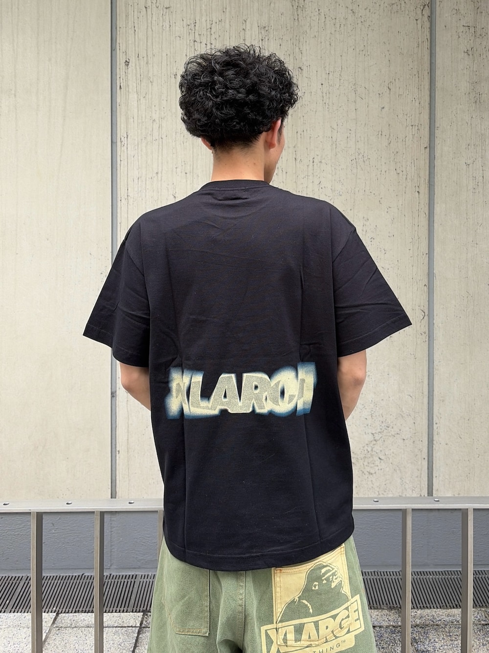 グリーン系のデニムパンツ、ブラック系のTシャツ/カットソーを着用したメンズの春コーディネートの6枚目の写真