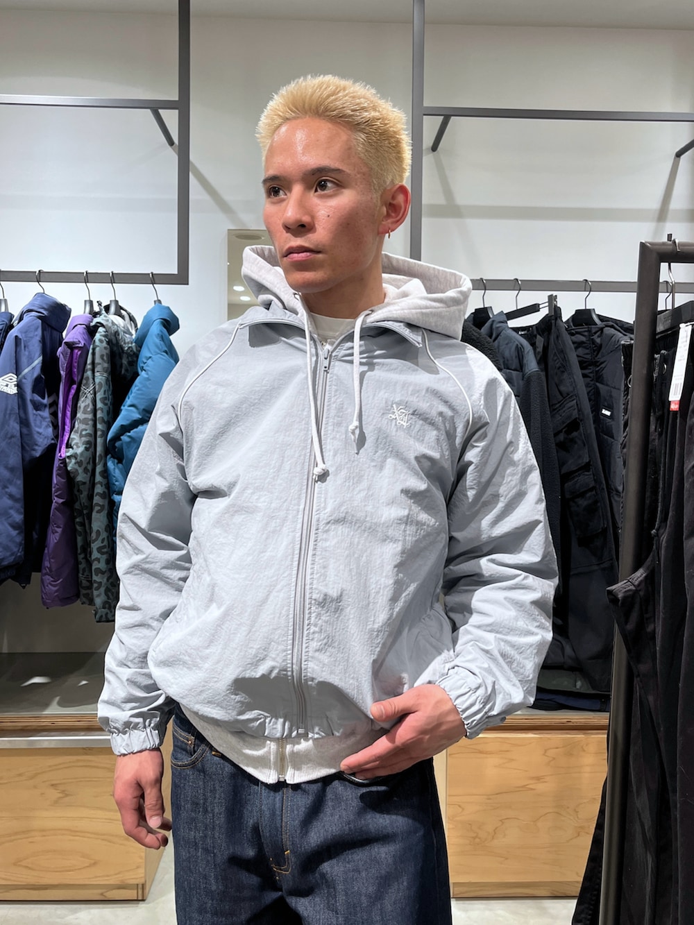 グレー系のナイロンジャケット、ブルー系のデニムパンツを着用したメンズの冬コーディネートの5枚目の写真