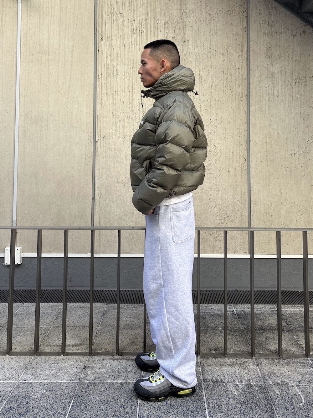 グリーン系のダウンジャケット/コート、グレー系のスウェットパンツを着用したメンズの冬コーディネートの3枚目の写真
