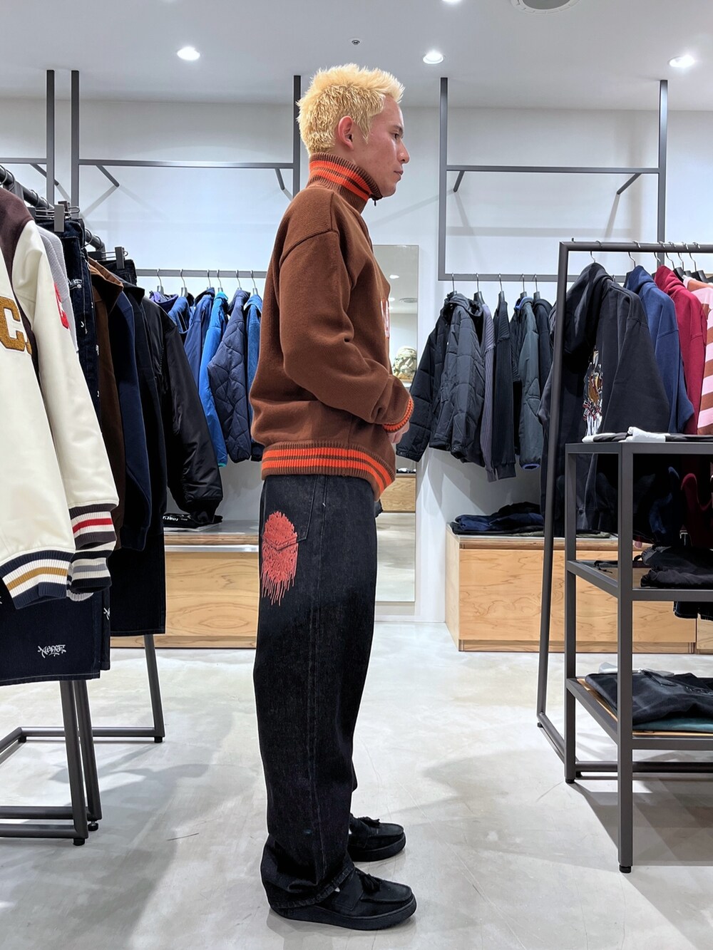 ブラック系のデニムパンツ、ブラウン系のニット/セーターを着用したメンズの秋コーディネートの3枚目の写真