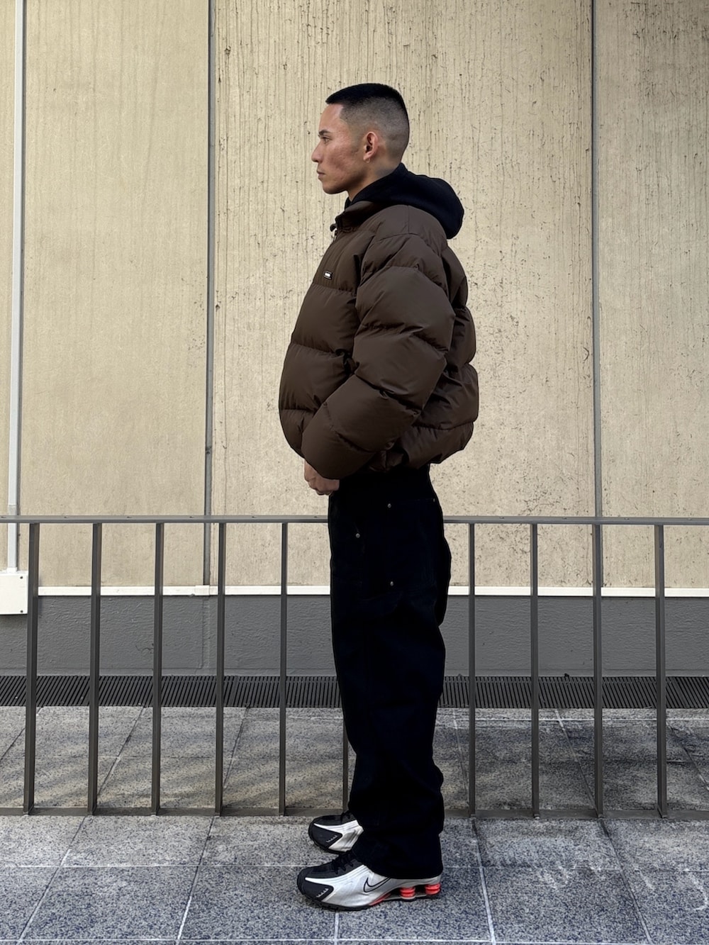 ブラック系のダウンジャケット/コート、ブラウン系のその他パンツを着用したメンズの冬コーディネートの2枚目の写真