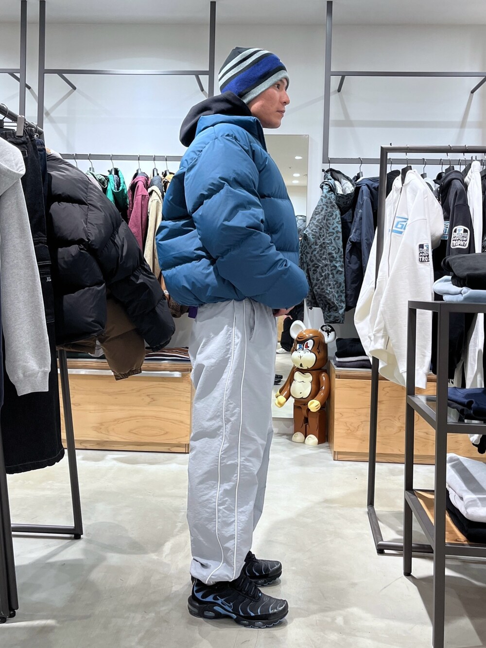 ブルー系のダウンジャケット/コート、グレー系のその他パンツ、ブラック系のニットキャップ/ビーニーを着用したメンズの秋コーディネートの4枚目の写真