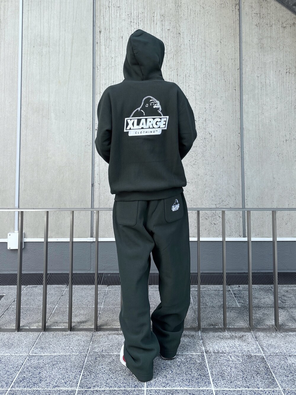 グリーン系のパーカー、グリーン系のスウェットパンツ、ブラック系のキャップを着用したメンズの秋コーディネートの6枚目の写真