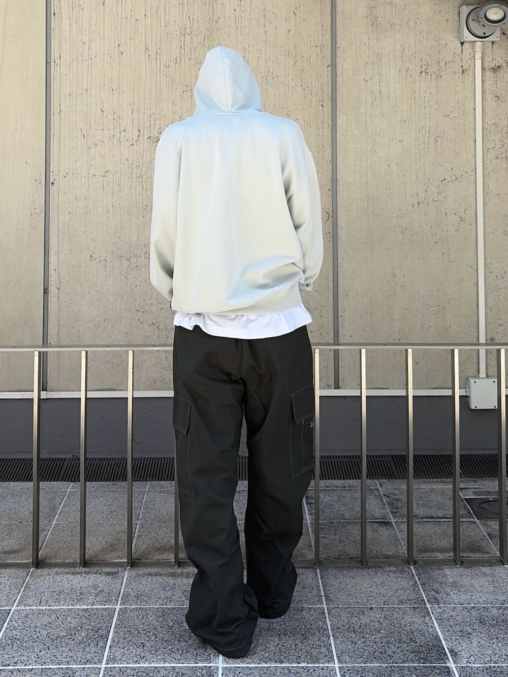 ブラック系のパーカー、グリーン系のカーゴパンツ、グリーン系のキャップを着用したメンズの夏コーディネートの5枚目の写真