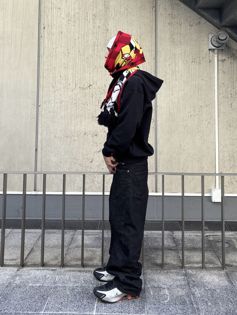 ブルー系のデニムパンツ、ブラック系のパーカー、ピンク系のニットキャップ/ビーニーを着用したメンズの冬コーディネートの2枚目の写真