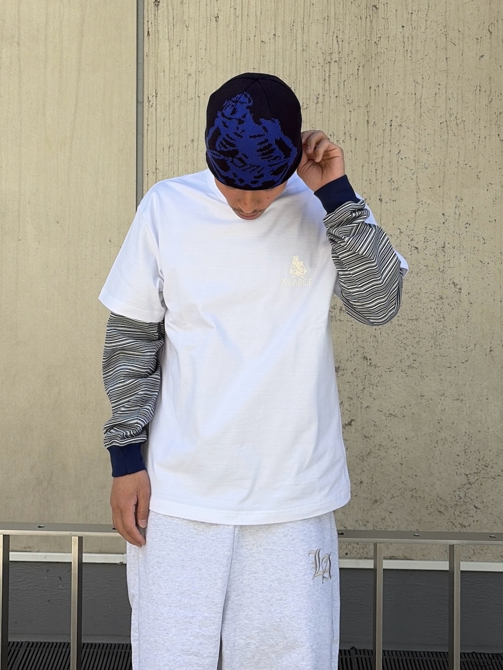 ホワイト系のTシャツ/カットソー、ブルー系のTシャツ/カットソー、グレー系のスウェットパンツを着用したメンズの春コーディネートの5枚目の写真