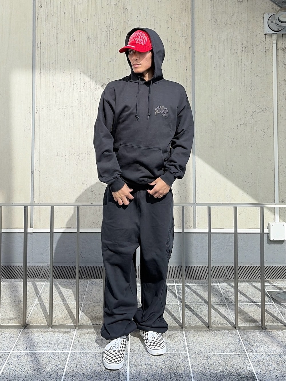 ブラック系のパーカー、ブラック系のその他パンツ、レッド系のキャップを着用したメンズの夏コーディネートの2枚目の写真